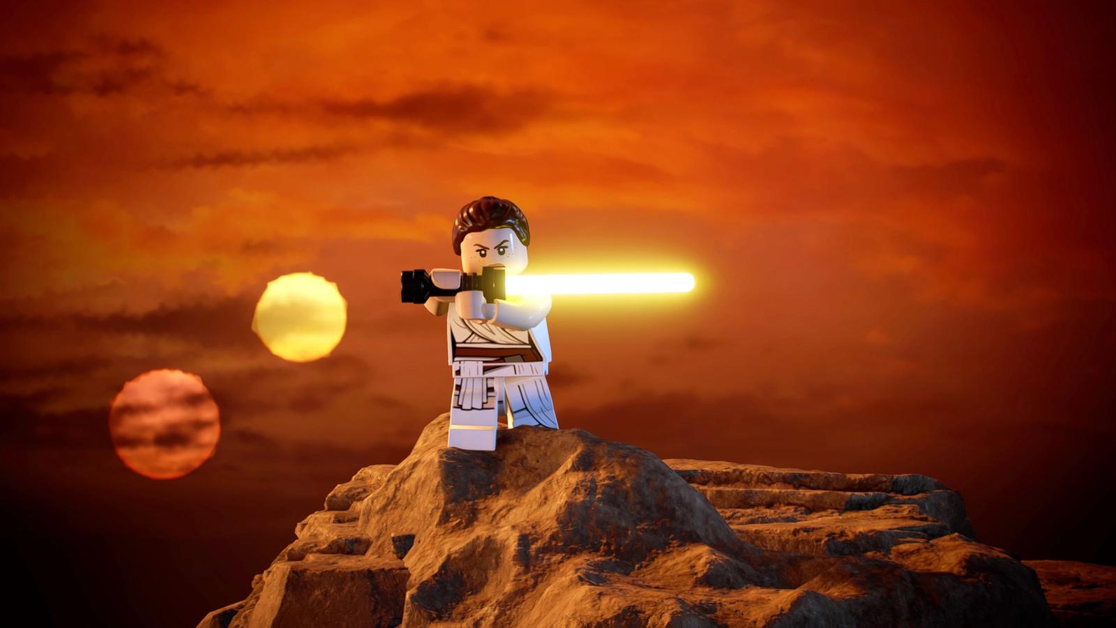 Rey from Lego Star Wars holding up her lightsaber in front of a sunset.