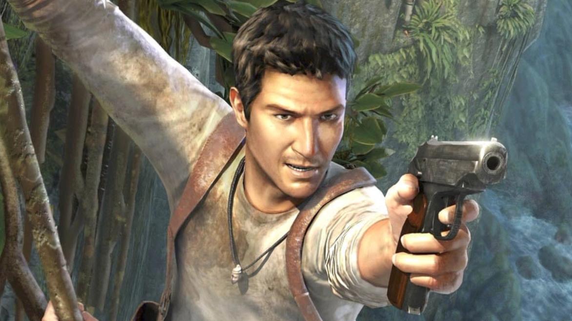 Nathan Drake holding onto a cliff and aiming a pistol at the camera 