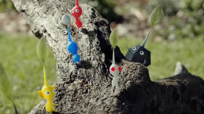Some Pikmin of different styles stumble about on a log in Pikmin Bloom.