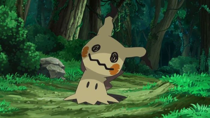 A Mimikyu is stood in a forest.