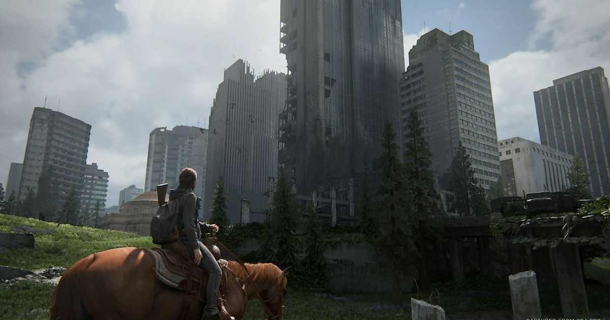 Ellie on a horse and looking at a derelict city in The Last of Us Part 2.