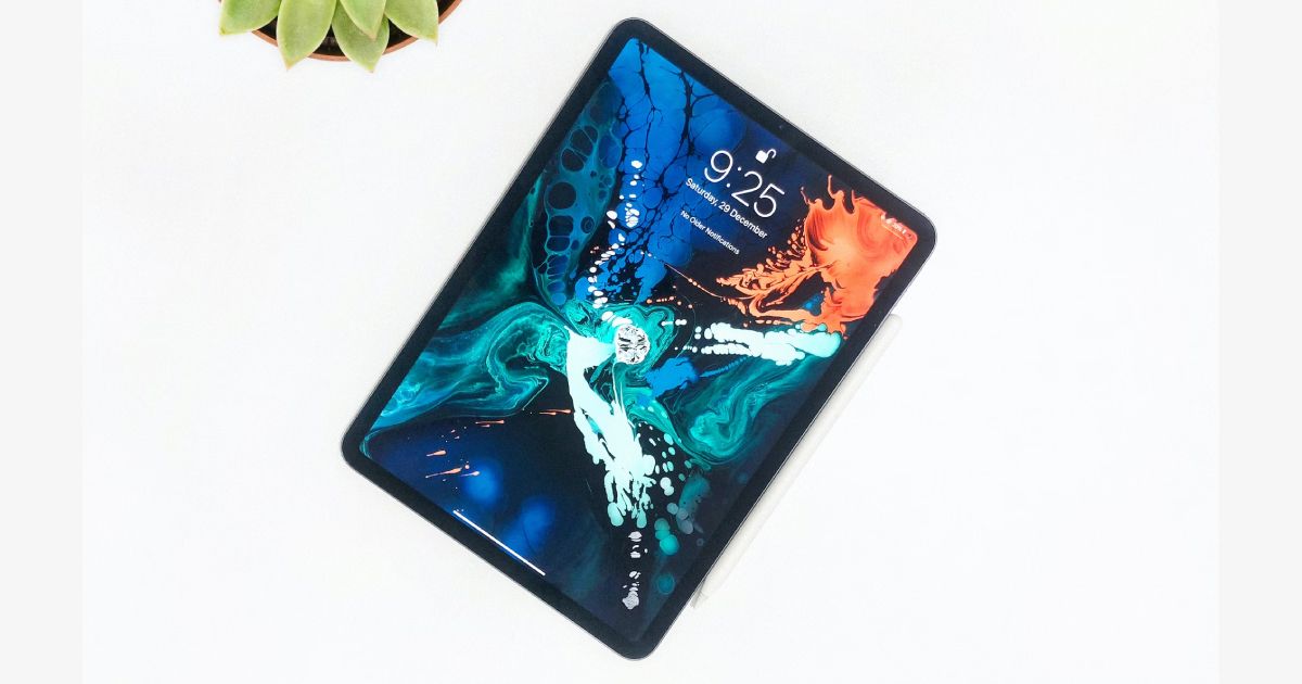 A black and blue floral pattern with orange details on the screen of a black iPad.