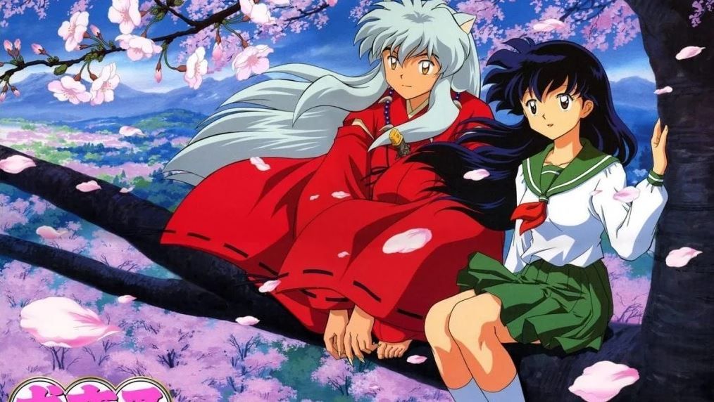 A boy and a girl are sat on a branch of a blossoming cherry tree.
