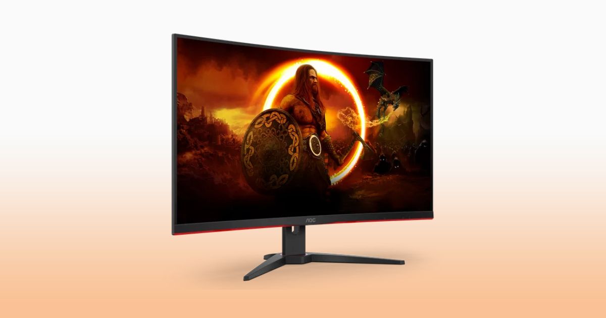 A black gaming monitor with red trim and a viking solider on the display in front of a white and orange gradient background.