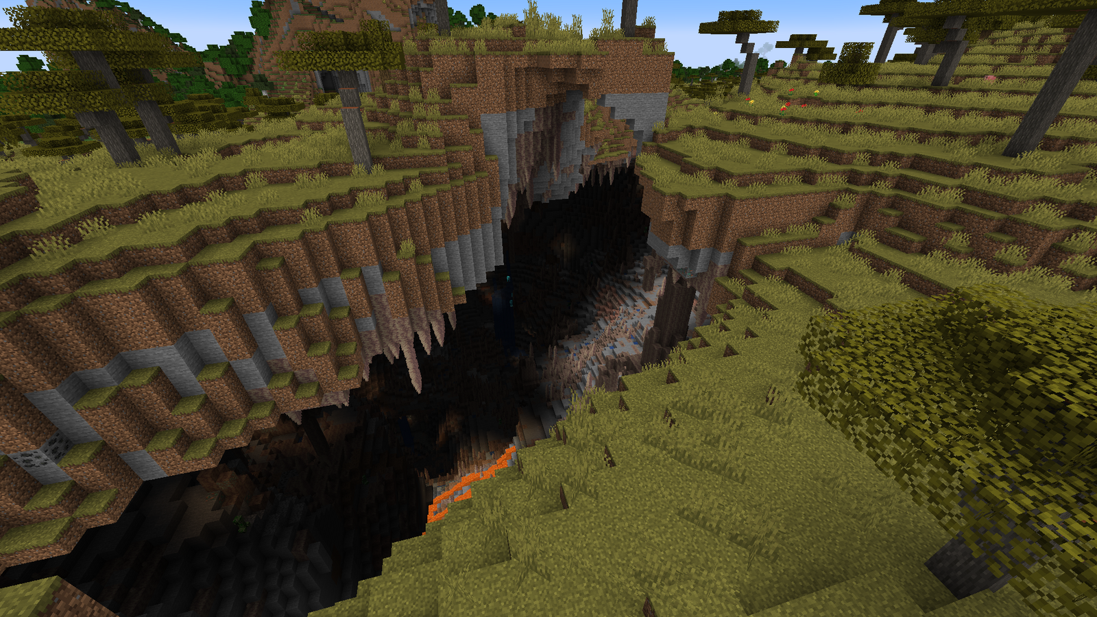 A large Minecraft cave, with lava at the bottom.