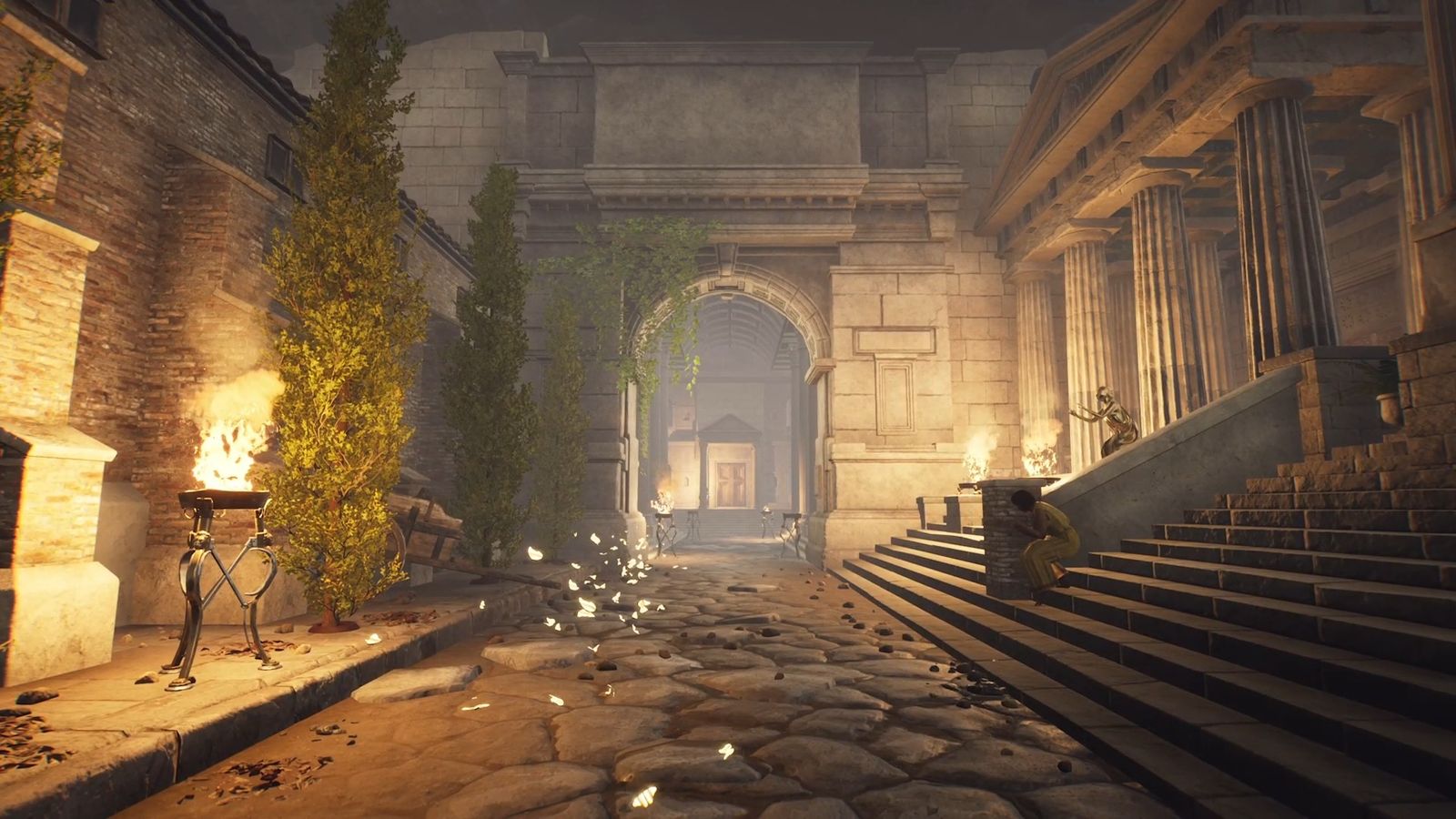 The Forgotten City. The image shows the entrance to the baths. The woman in a yellow dress is cowering on the steps to the right. There is a flame-lit torch on the left. 