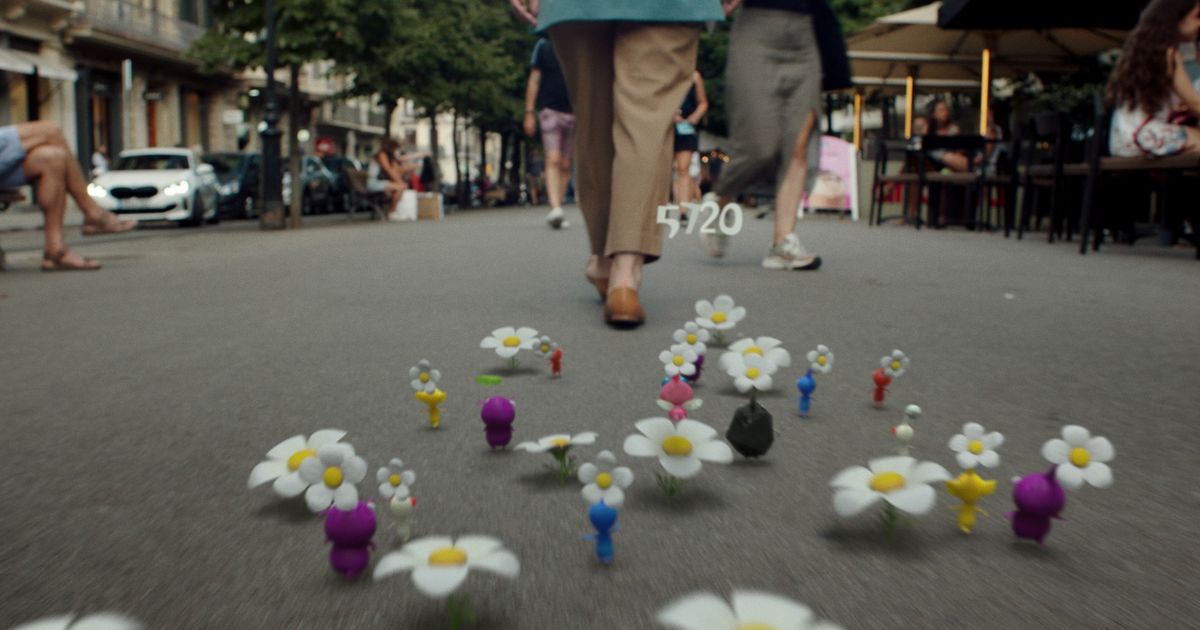 Screenshot from Pikmin Bloom, showing several Pikmin walking along a street