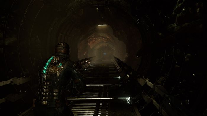 Isaac walking down a dark hallway in the Dead Space remake.