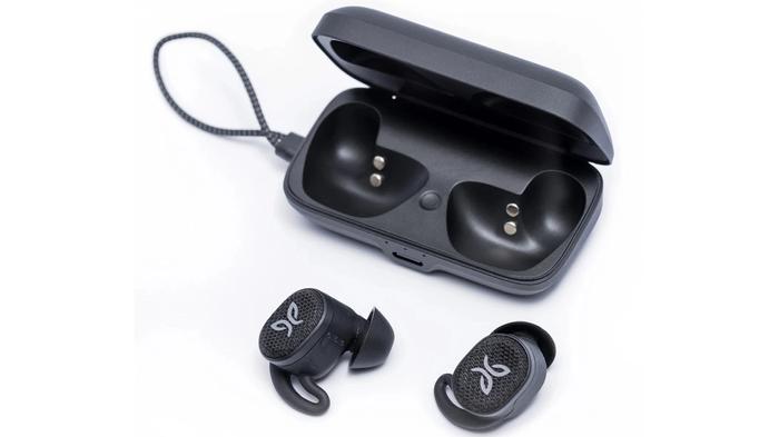 A pair of Jaybird Vista 2 earbuds lie next to their charging case