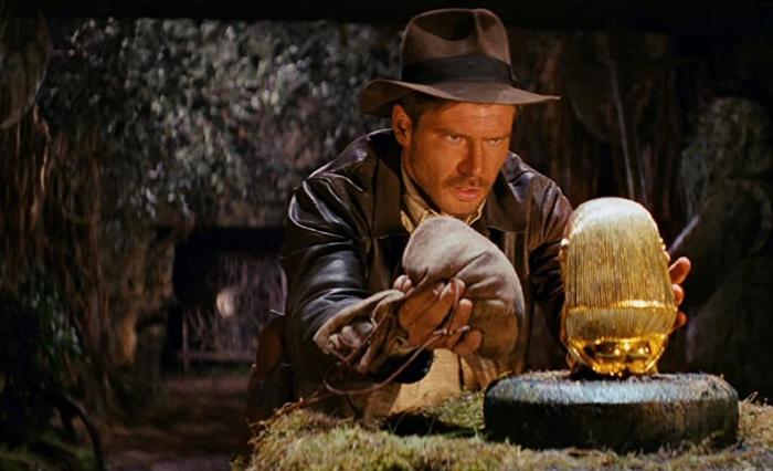 Indiana Jones attempts to replace a gold statue with a bag of sand.