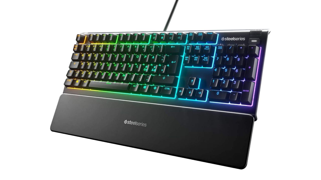 SteelSeries Apex 3 product image of a black keyboard with a wrist rest and multicoloured backlit keys.