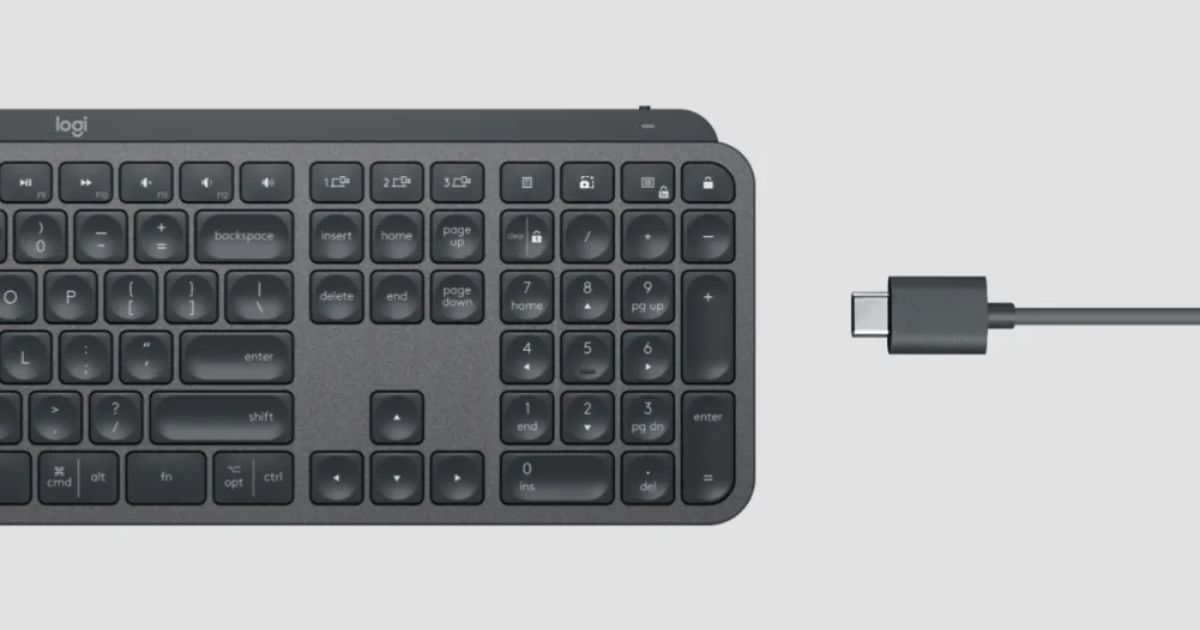 A black keyboard on the left with a black cable being plugged into it on the right.