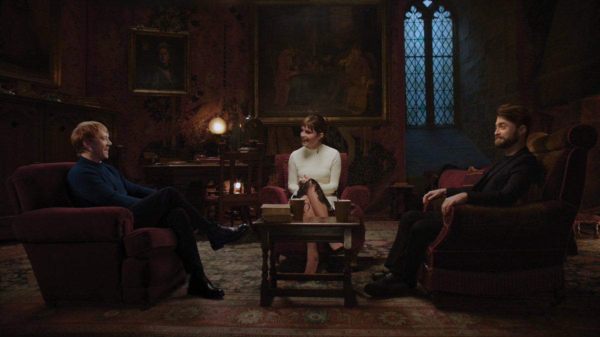 Rupert Grint (left), Emma Watson (middle), and Daniel Radcliffe (right) are sitting facing each other.
