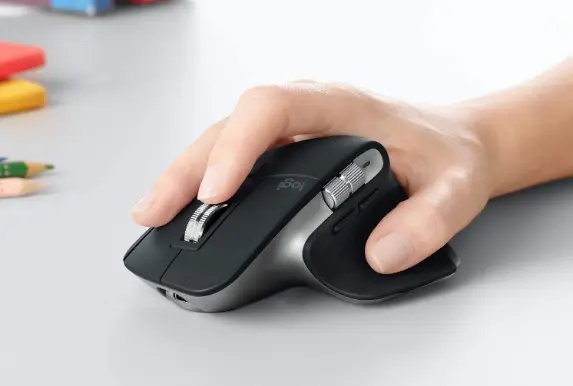 Someone with their hand on a black and silvery grey ergonomic mouse.