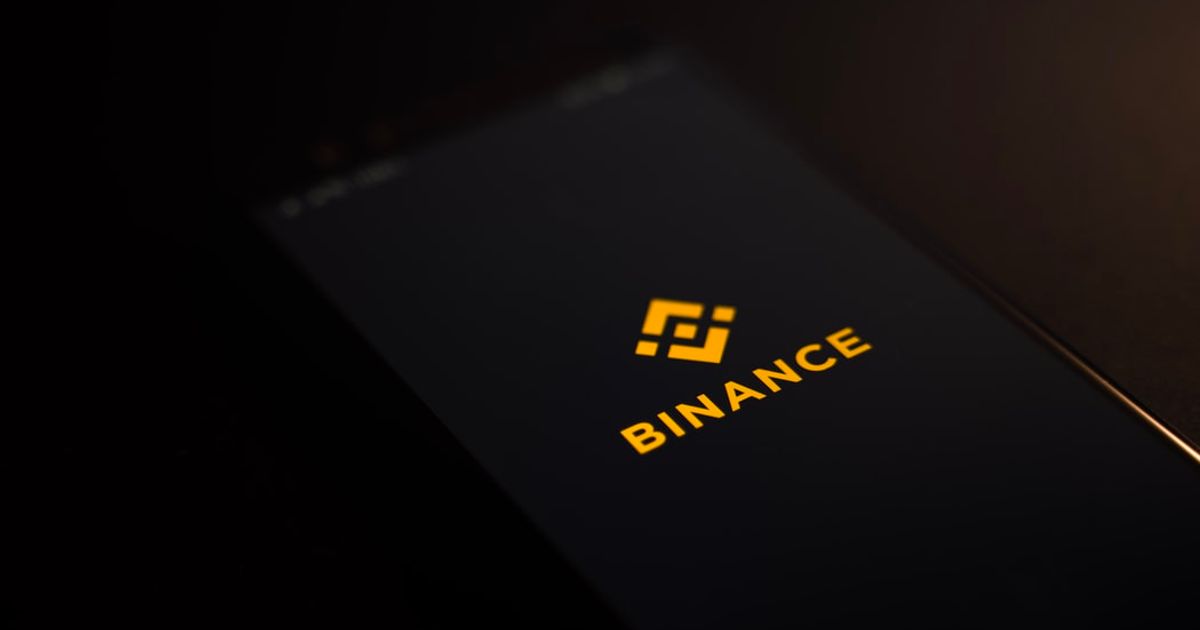 Binance logo on a phone on a dark background.