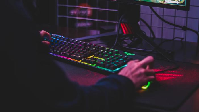 Someone playing video games using a keyboard and mouse
