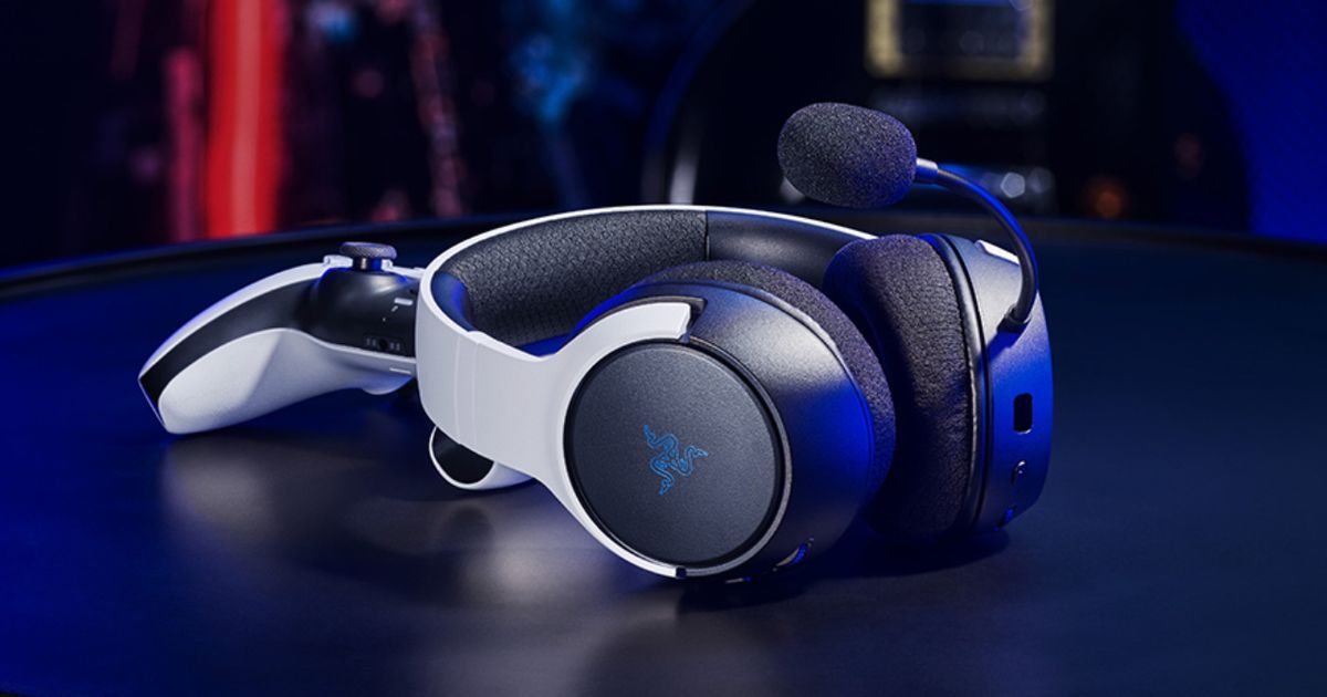 A white and black headset with Razer branding on the side leaning against a white and black PS5 controller.