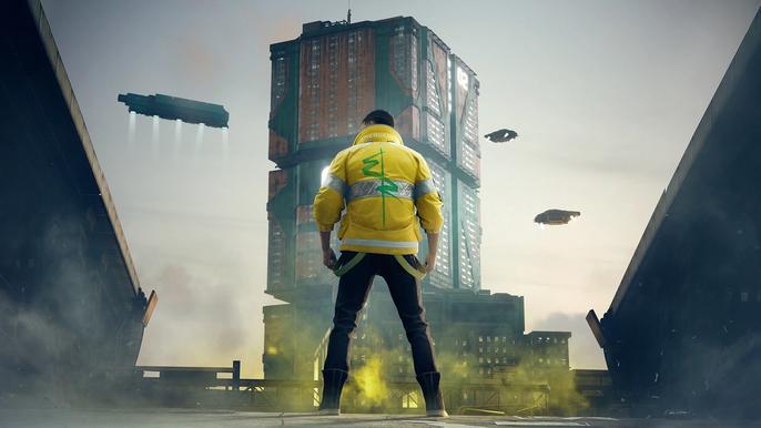 A man in a yellow jacket is standing in front of a city building.